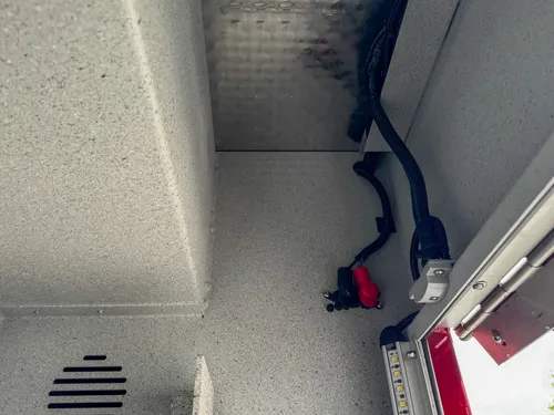 Compartment interior side view with shelf support bracket and wall panel.